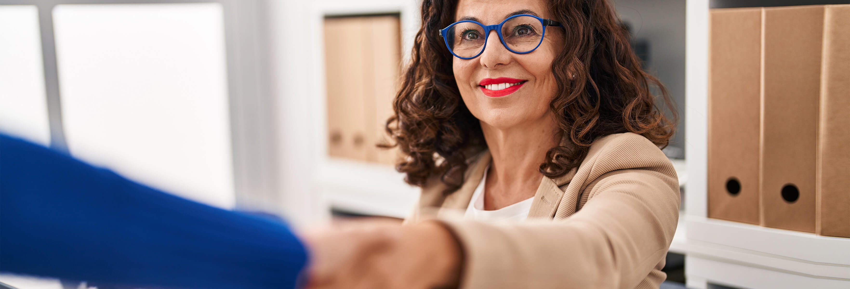 Smiling woman with glasses shaking hands