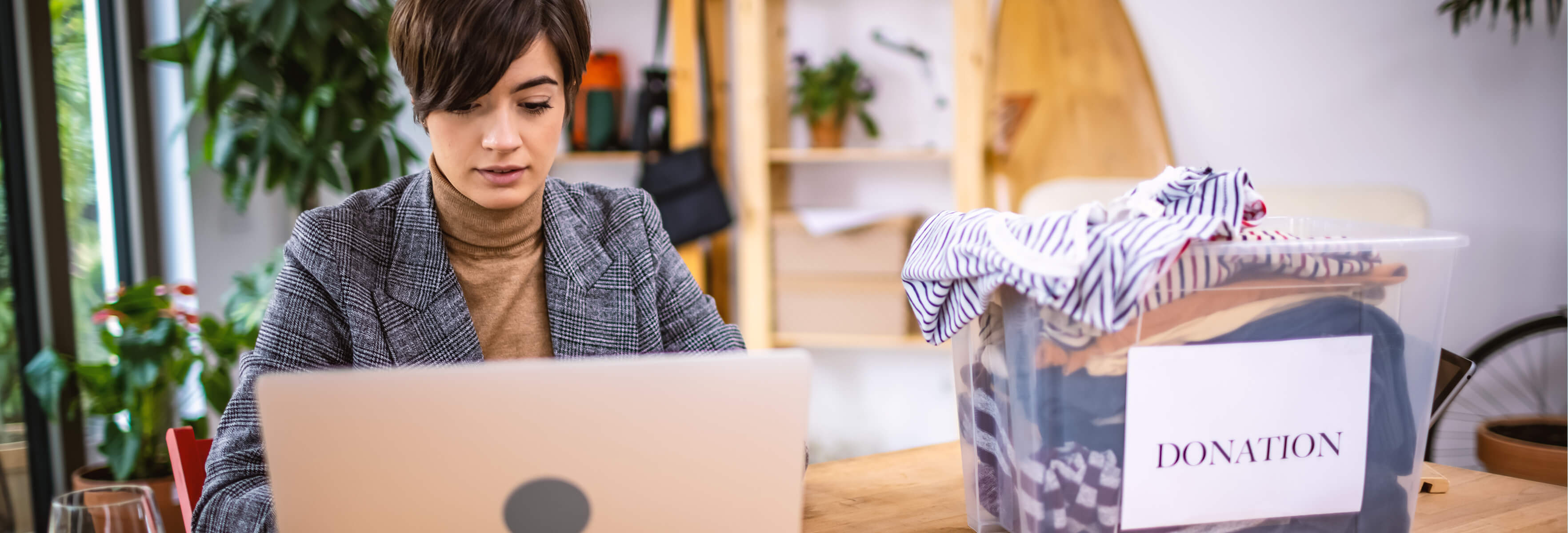 Woman on her desk, looking at laptop