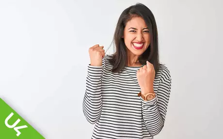 Smiling woman with both arms half raised and fists clenched in celebration