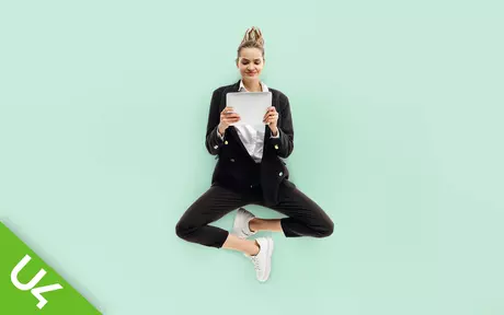 Woman floating in mid air holding tablet computer