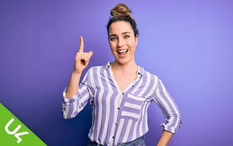 smiling woman with one arm half raised and pointing upwards