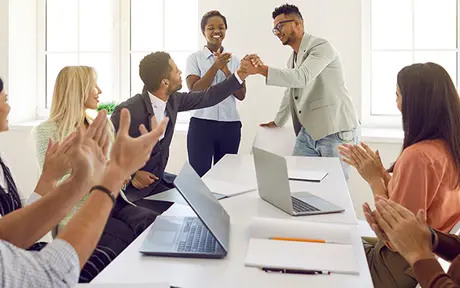 Eight individuals in a bright, modern office setting. 