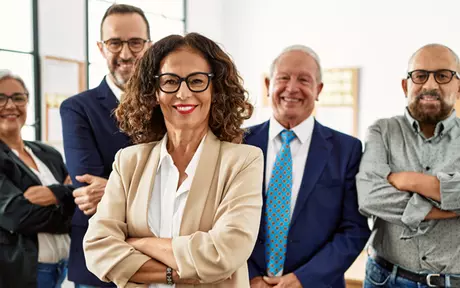 Smiling woman standing in front of her colleagues