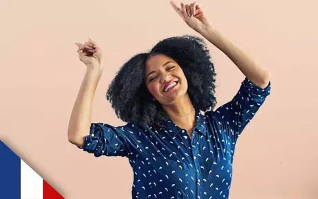 Smiling woman with both arms half raised and fists clenched in celebration