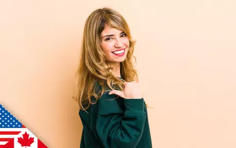 Woman smiling and pointing thumb backwards over her shoulder