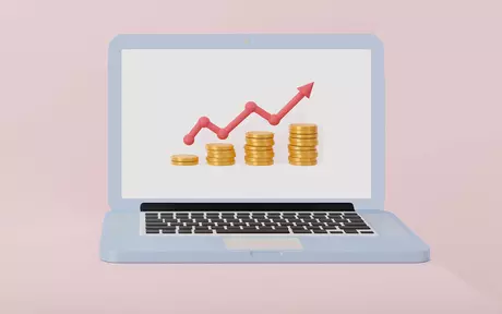 laptop with graph and coins