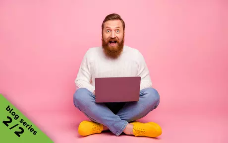 man smiling behind laptop