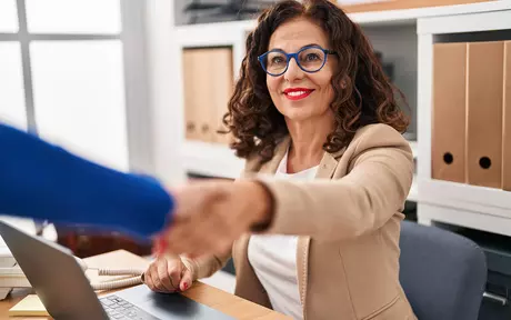 Smiling woman with glasses shaking hands