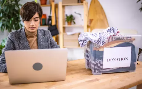 Woman on her desk, looking at laptop