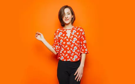 young girl in red shirt in orange background  card image