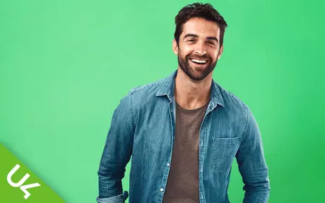 smiling man looking straight ahead on a mid green background